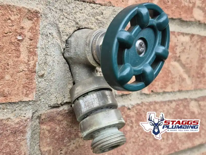 Leaky outdoor spigot dripping water near a home's foundation. Staggs Plumbing recommends fixing dripping hose bibbs quickly to prevent mold, soil expansion, and slab leaks around your foundation.